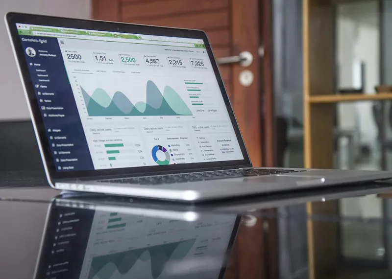 Laptop displaying charts and analytics on a wooden desk